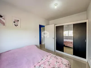 Quarto com cama rosa e paredes brancas em um imóvel no Brasil.
