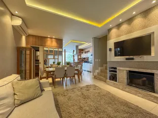 Sala de estar e cozinha em um apartamento moderno com iluminação embutida.