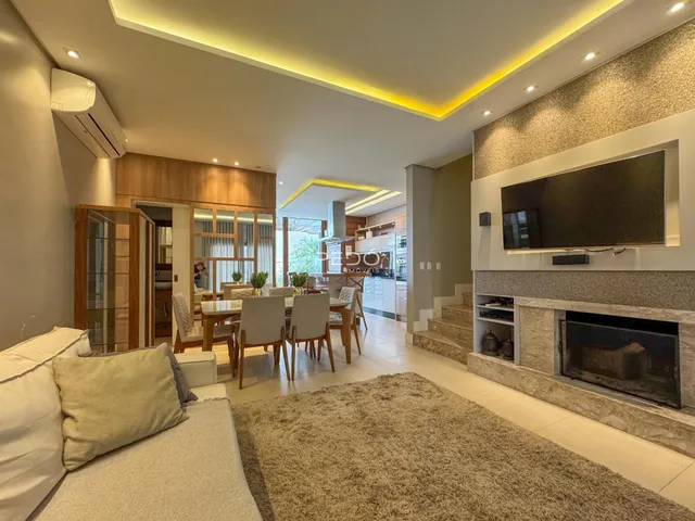 Sala de estar e cozinha em um apartamento moderno com iluminação embutida.