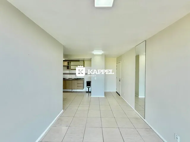 Hall de corredor com piso de cerâmica e vista para a cozinha.