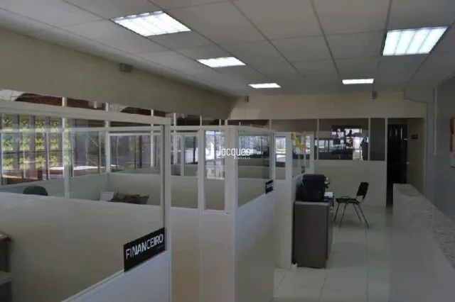 Corredor interno de uma residência com paredes brancas e piso claro.