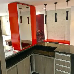 Foto de um ambiente interno mostrando armários e bancadas em tons de laranja.