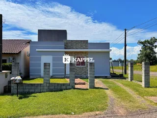 Fachada externa de uma residência em Lajeado, Brasil, com muro de contenção e gramado.