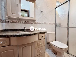 Foto de um banheiro mostrando a bancada e o vaso sanitário.