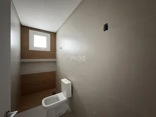 Foto interna de um banheiro com revestimento de cerâmica e louças sanitárias brancas.
