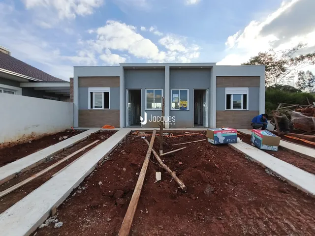 Vista externa de uma casa em construção no terreno.
