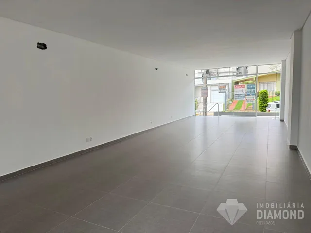 Interior de um espaço amplo com piso de cerâmica e paredes brancas.