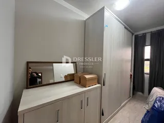 Quarto com guarda-roupa e espelho em um imóvel no Brasil.