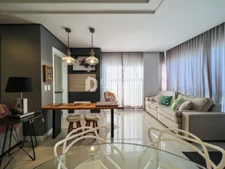 Sala de estar moderna com grandes janelas e piso reflexivo.