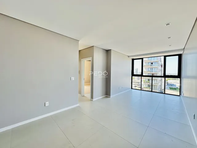 Ambiente interno de uma sala ampla com paredes brancas.