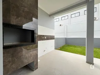 Imagem de um ambiente interno com parede de destaque e área externa gramada.