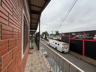 Vista externa de uma parede de tijolos e um caminho pavimentado em uma propriedade.