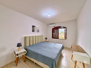 Quarto com cama e janela em ambiente claro.