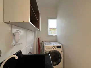 Foto de um interior mostrando armários e uma máquina de lavar roupa.