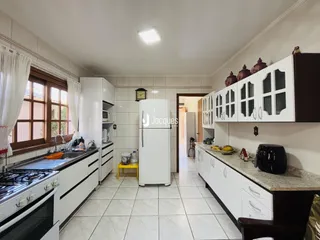 Vista da cozinha de um imóvel em Lajeado, Brasil, com armários brancos e piso cerâmico.