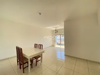 Vista interna de um ambiente com mesa de jantar e piso cerâmico.