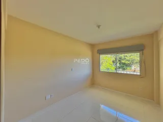 Interior de uma sala com paredes amarelas e piso branco.