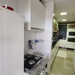 Foto de uma cozinha moderna com armários brancos e bancada clara.