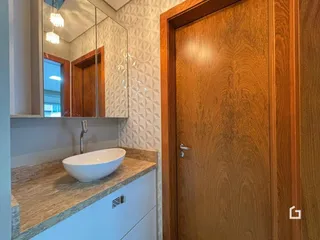 Foto de um banheiro com bancada de granito e pia branca.