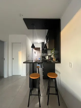 Interior de um ambiente com balcão e bancos de bar.