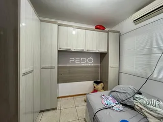 Quarto com armários brancos e cama em um imóvel no Brasil.