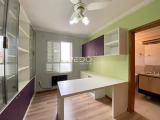 Sala de estar com paredes verdes e piso de madeira clara.