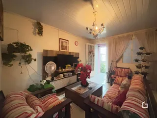 Sala de estar com decoração de madeira e cortinas brancas.