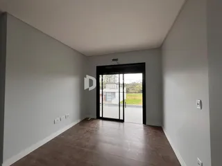 Vista interna de um ambiente com piso de madeira e porta de vidro.