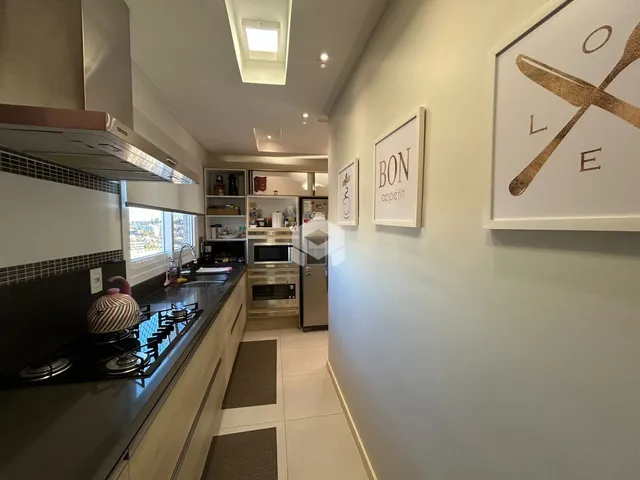 Vista da cozinha moderna com armários e bancadas claras.