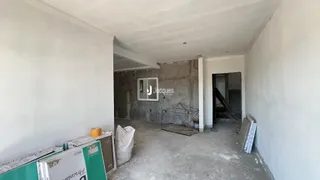 Interior de uma área em construção com paredes de concreto.