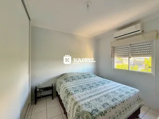 Quarto com cama e janela com persianas em um imóvel residencial.