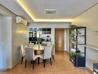 Ambiente interno de sala de jantar com piso de madeira e móveis.