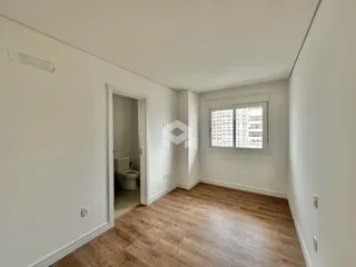 Vista interna de um ambiente com piso de madeira clara.