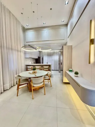 Uma sala de jantar moderna com mesa redonda e cadeiras de madeira clara.