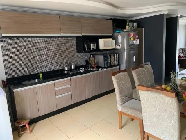 Cozinha moderna com armários escuros e bancada preta.