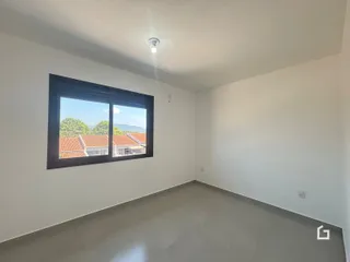 Uma sala de estar com grande janela de vista para o exterior.