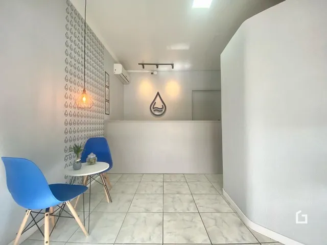 Imagem de um corredor interno com piso de cerâmica clara e decoração de parede.