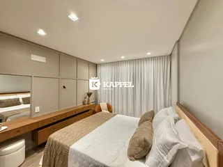 Quarto com cama grande e cabeceira de madeira em um ambiente claro.