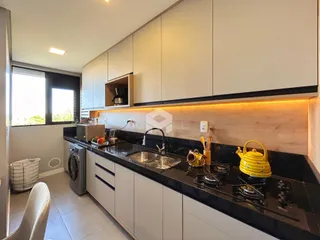 Cozinha moderna com armários e bancada escura.