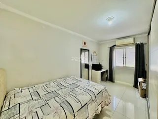 Quarto com cama e janela em ambiente claro.