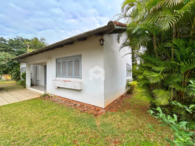 Fachada de uma casa em Lajeado, Brasil, com jardim gramado e vegetação ao redor.