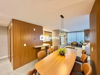 Foto de uma sala de jantar com mesa de madeira e cadeiras em um apartamento.