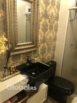 Foto de um banheiro com revestimento de parede estampado e pia preta.
