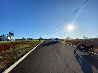 Uma estrada asfaltada se estende por uma paisagem aberta sob um céu azul.