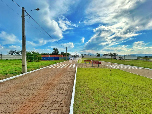 Vista da fachada de uma propriedade com gramado e estrada no Brasil.