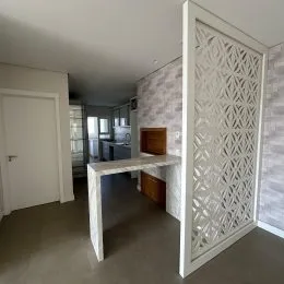 Hall de entrada com divisória decorativa branca na propriedade.