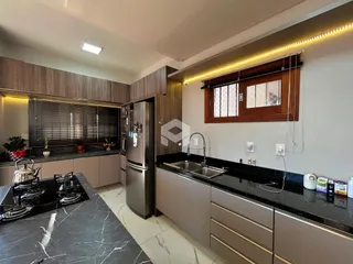 Vista da cozinha de um imóvel em Lajeado, Brasil, com armários e bancadas escuras.