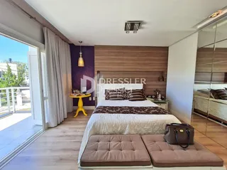 Quarto com cama e portas de vidro abrindo para o exterior.