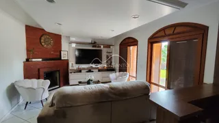 Sala de estar com sofá, poltronas e lareira em ambiente interno.