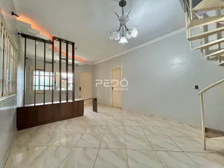 Sala de estar com piso de cerâmica e detalhes em madeira na residência.